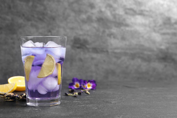 Organic blue Anchan with lemon in glass on grey table, space for text. Herbal tea
