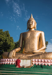 Portrait of a monk praying with the largest Buddha in South America.