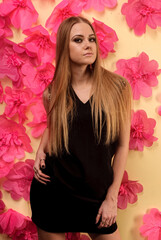 Obraz na płótnie Canvas Beautiful girl with long hair at flowers background