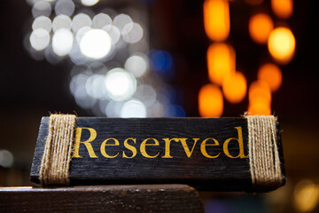 Plaque with the inscription Reserved on the restaurant table.