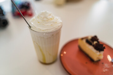 Batido de helado y porcion de tarta en mesa de cafeteria