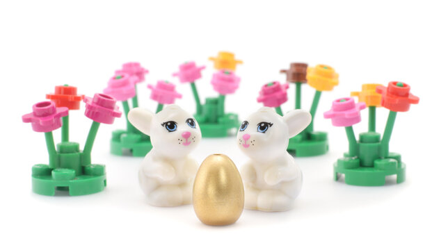 Lego figure happy white bunny is hunting easter eggs. Editorial illustrative image of Easter holiday.