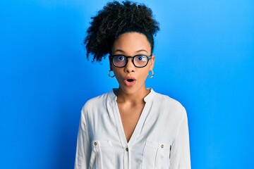 Young african american girl wearing casual clothes and glasses scared and amazed with open mouth...