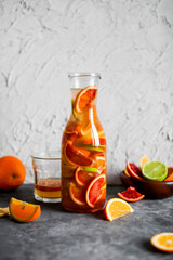 Mixed citrus lemonade in a tall glass jar. A drink made from red oranges, lemons and limes. Refreshing cold cocktails.