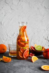 Mixed citrus lemonade in a tall glass jar. A drink made from red oranges, lemons and limes. Refreshing cold cocktails.
