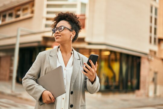 Young african american businesswoman smiling happy using smartphone at the city.