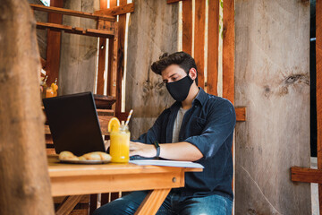 Young man wearing a protective mask in a bar.