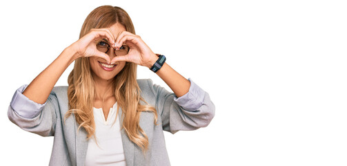 Beautiful blonde young woman wearing business clothes doing heart shape with hand and fingers smiling looking through sign