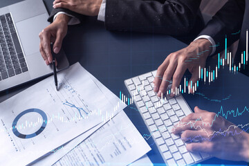 Two traders man and woman researching historic data to predict stock market behavior. Internet...