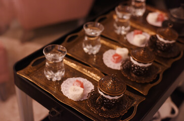 Turkish coffee in original forged cups and oriental sweets on a tray