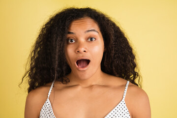 African-american woman portrait isolated on yellow studio background with copyspace