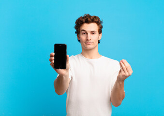 young boy making capice or money gesture, telling you to pay your debts!. telephone screen concept