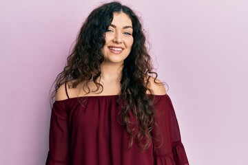 Young brunette woman with curly hair wearing casual clothes with a happy and cool smile on face. lucky person.