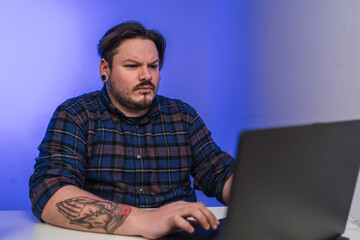 Chico tatuado frente al ordenador