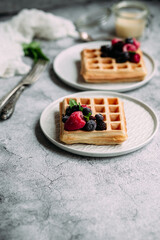 Belgian waffles with berries on a light plate.Breakfast