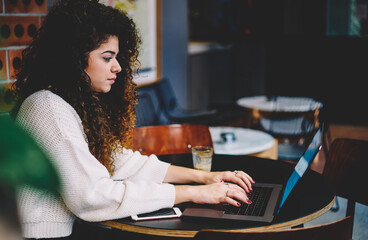 Beautiful female copywriter working with text article using laptop application for doing remote...