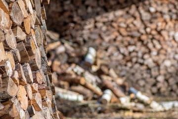 Obraz premium Structure or pile composed of blocks, pieces or logs of wood in winter or spring with snow. The art of stacking wood for drying and storage