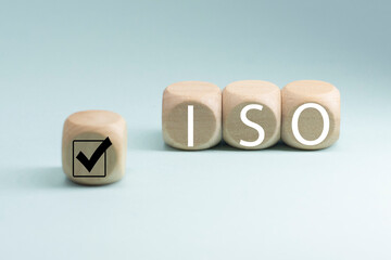 The abbreviation ISO on wooden cubes with check mark . ISO quality control certification approval...