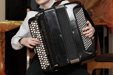 Young musician accordionist player boy with bayan in his hands close up, teaching children in a music school in Russia
