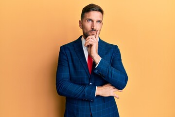 Handsome man with beard wearing business suit and tie serious face thinking about question with...