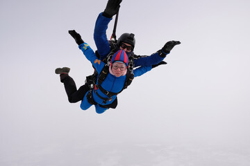 Fototapeta na wymiar Skydiving. Tandem jump. Man and woman. Winter season.