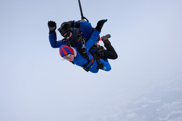 Skydiving. Tandem jump. Man and woman. Winter season.