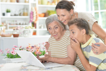 Happy family in front of laptop in kitchen