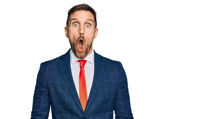 Handsome man with beard wearing business suit and tie afraid and shocked with surprise expression, fear and excited face.