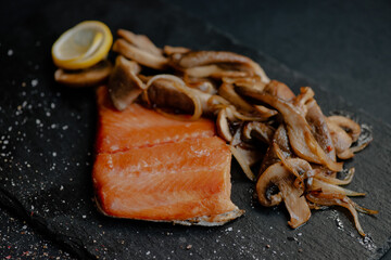 Delicious smoked fish fillet prepared in various ways and arranged on different plates with tasty healthy burger and salad meals