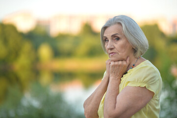 Portrait of sad senior beautiful woman in park