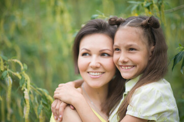 Happy mother and daughter at summer field