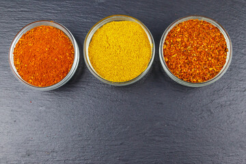 Set of different aromatic spices on black slate. Top view