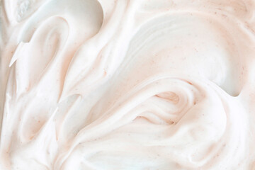 Creamy texture of white airy scrub foam with peeling particle. Gentle cosmetic background with warm...