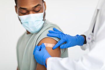 Man Getting Vaccinated Against Covid-19, Doctor Applying Plaster, White Background
