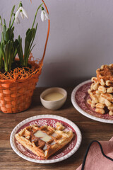 Homemade Belgian Waffles served with condensed milk on wooden background. Breakfast. Selective focus