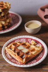 Homemade Belgian Waffles served with condensed milk on wooden background. Breakfast. Selective focus
