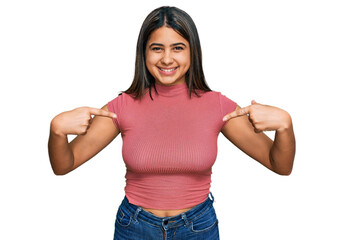 Obraz premium Young hispanic girl wearing casual t shirt looking confident with smile on face, pointing oneself with fingers proud and happy.
