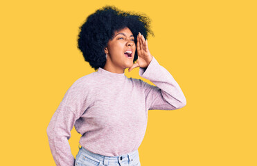 Young african american girl wearing casual clothes shouting and screaming loud to side with hand on...