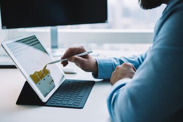 Unrecognizable male employee drawing chart on tablet with stylus