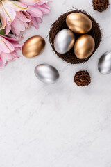 Design concept of Golden and silver Easter eggs in the nest with pink lily flower.