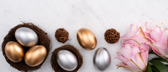 Design concept of Golden and silver Easter eggs in the nest with pink lily flower.