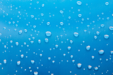 Moisturizing liquid blue drops on pastel background. Cosmetic toner or Water Drops. Hyaluronic serum Bubbles close-up.