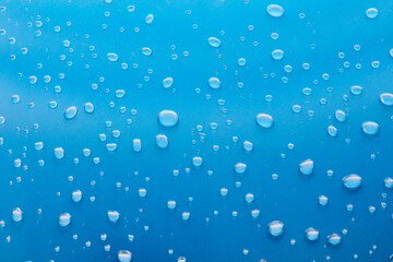 Moisturizing liquid blue drops on pastel background. Cosmetic toner or Water Drops. Hyaluronic serum Bubbles close-up.