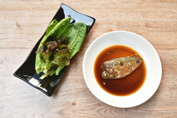 boiled mackerel fish sauce soup on plate with fresh vegetable
