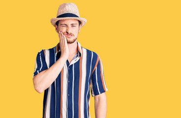 Young handsome caucasian man wearing summer hat touching mouth with hand with painful expression because of toothache or dental illness on teeth. dentist