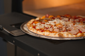 The cook takes the pizza out of the oven