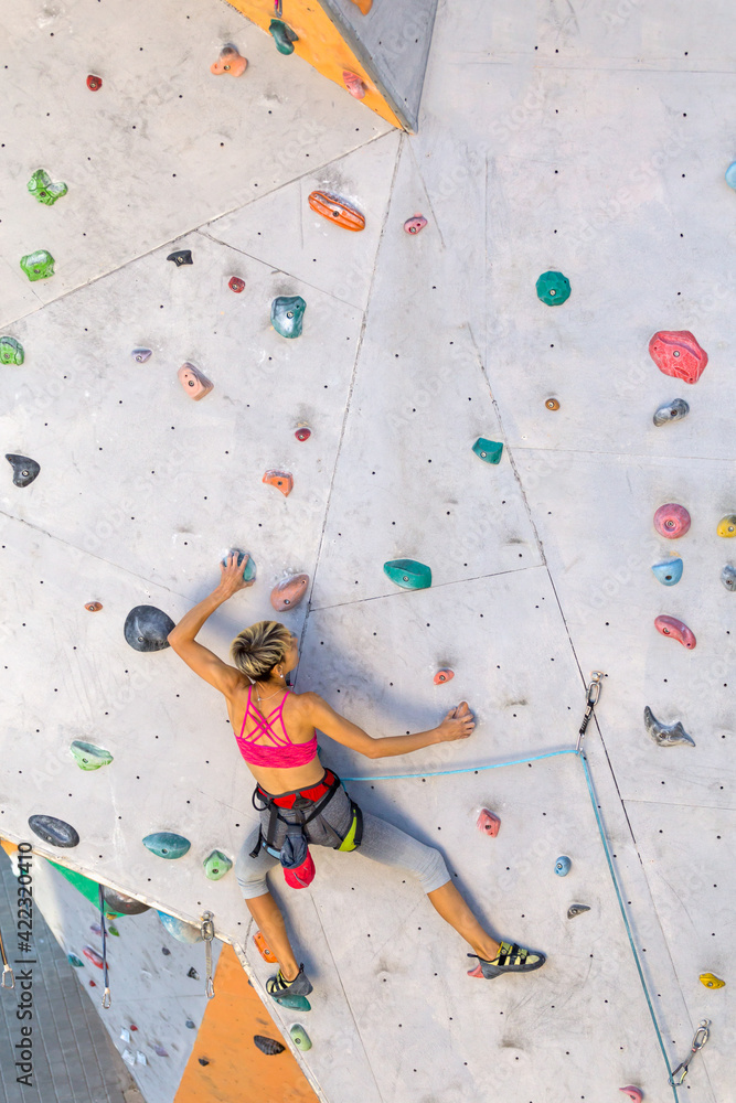 Canvas Prints a woman is climbing a climbing wall