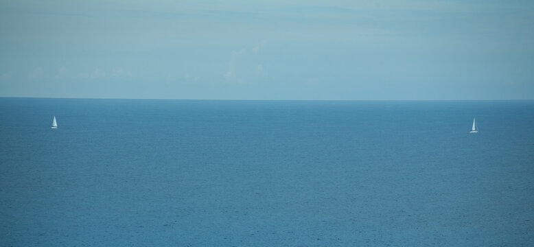 Two white sailboats on the horizon on the sea. Mallorca. Spain. 