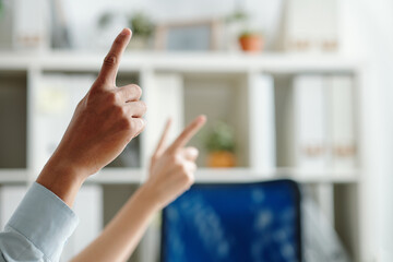 Hands of employees raising hands to ask question at business conference, focus on foreground