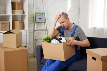 portrait of tired loader sitting on sofa in room .after moving day